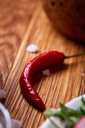 Red hot chilly pepper on rustic wooden background, close-up, shallow depth of field, selective focus, vertical. Burning condiment. Mexican seasoning. Organic natural spice. Detailed studio shot. Organic food concept.の写真素材