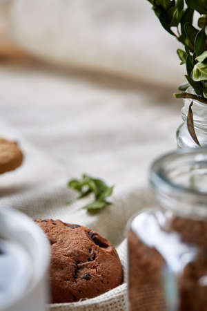 Breakfast background with porcelain mug of fresh black coffee, homemade oatmeal cookies on cutting...