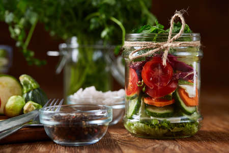 Perfect still life with fresh vegetable salad and ripe veggies on cutting board over wooden...