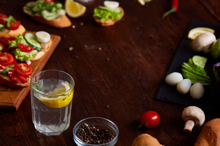 Breakfast sandwich with homemade paste, vegetables and fresh greenson wooden cutting board over...