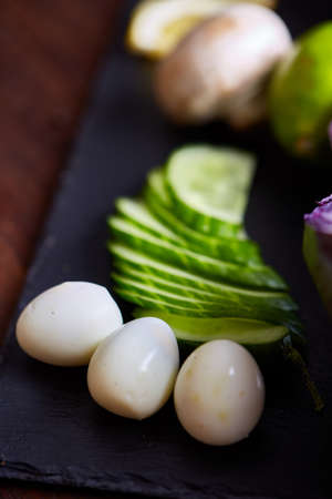 Breakfast still life with sandwiches, quail eggs, spicies and fresh fruits and vegetables on rustic wooden background, selective focus. Gourmet buckish starter. Delicious excuisite appetizer. Sofisticated cuisine. Food concept.の写真素材