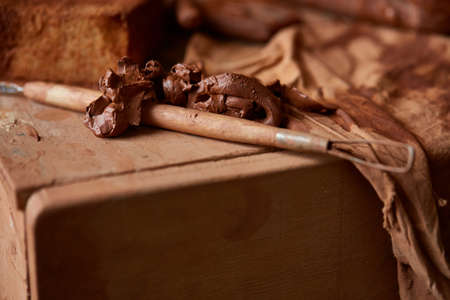 Conceptual still life with art and sculpture tool in the potter workroom, close-up, shallow depth of field. Tools for creation and inspiration. Handicraft equipment. Sculpture set for skillful potter. Art and crafts concept.の写真素材