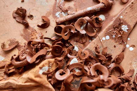 Red clay shavings on the worktop background, top view, close-up, shallow depth of field. Pottery work backstage. Grunge background. Decorative modeling. Art and crafts concept.の写真素材