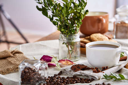 Morning coffee in white porcelain cup, crispy chocolate chips cookies on cutting board over wooden table, close-up, selective focus, side view. Ceramic mug with hot beverage. Gourmet morning drink. Homemade stillness. Breakfast concept,の写真素材