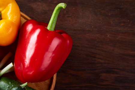 Combination of fresh organic green, yellow and red pepper on rustic wooden background, top view, close-up, selective focus. Heap of organic bell peppers. Studio shot. Fresh tasty salad ingredient. Healthy food concept.の写真素材