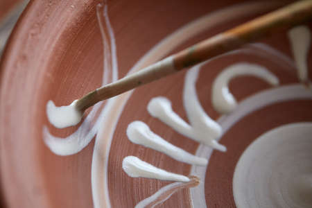 Scary face alike handmade potter mug on a wooden shelf, close-up, shellow depth of field.の写真素材