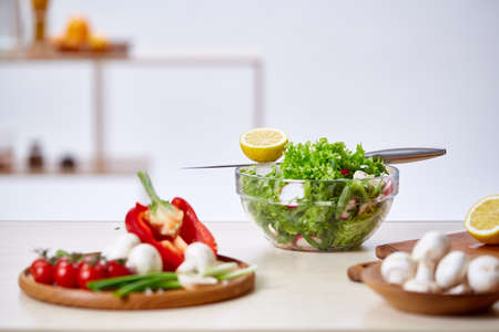 Man cooking at kitchen making healthy vegetable salad, close-up, selective focus.の写真素材