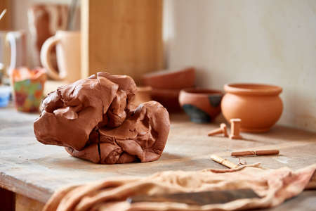Adult male potter master modeling the clay plate on potters wheel. Top view, closeup, hands only.の写真素材