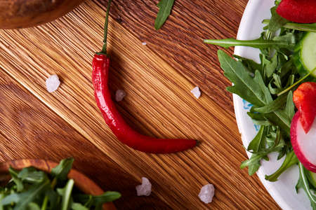 Fresh red radish in wooden bowl among plates with vegetables, herbs and spicies, top view, selective focus.の写真素材
