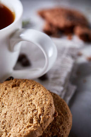 Breakfast background with mug of fresh coffee, homemade oatmeal cookies, grind coffee