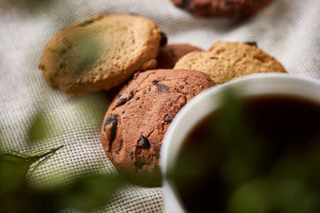 Breakfast background with mug of fresh coffee, homemade oatmeal cookies, grind coffee