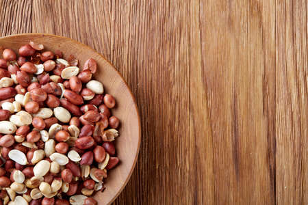 Two ceramic bowls with raw peanuts mix isolated over rustic wooden backround, top view, close-up.の写真素材