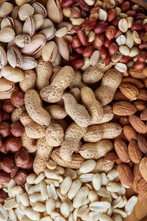 Mixed nuts arrenged on wooden tray over rustic background, close-up, selective focus.の写真素材