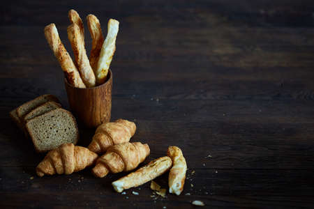 Puff pastries on dark wooden table, close-up, selective focus, backlight.の写真素材