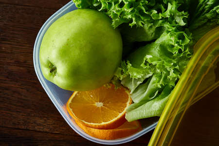 Healthy lunch prepared in small plastic container, top view, close-up.