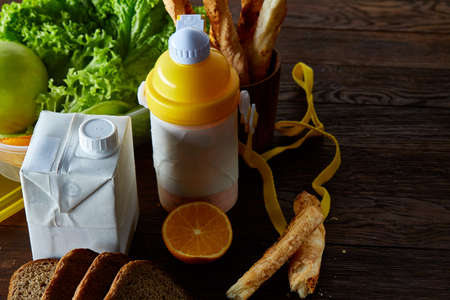Continental breakfast with fresh pastry, fruits, greenery and beverages over rustic wooden...