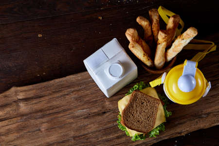 Delicious breakfast concept with fresh pastry, milk and bottle of beverage over rustic wooden...