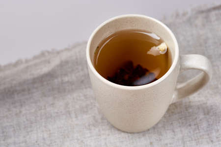 Cup of tea on table with sackcloth, top view, close-up, selective focusの写真素材