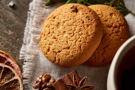 Traditional Christmas tea concept with dried oranges, cookies and decorations on a wooden table,...