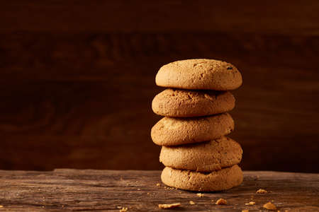 Pile of oat cookies on wooden table, close-up, selective focus. Crunchy stack. Delicious snack....