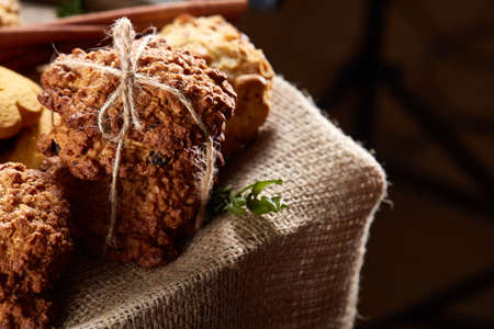 Conceptual composition with assortment of cookies and cinnamon on a wooden barrel, selective focus, close-upの写真素材