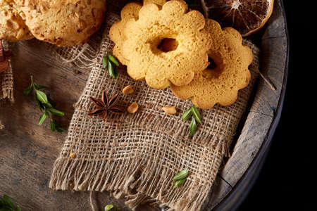 Conceptual composition with assortment of cookies on burlap napkin on a wooden barrel, selective focus, close-upの写真素材