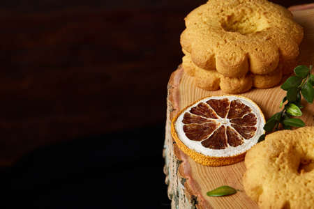 Christmas concept with assortment of cookies and decorations on a log over wooden background, selective focusの写真素材
