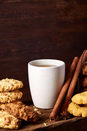 Traditional Christmas tea concept with a cup of hot tea, cookies and decorations on a wooden background, selective focusの写真素材