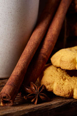 Traditional Christmas tea concept with a cup of hot tea, cookies and decorations on a wooden background, selective focusの写真素材