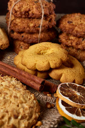 Conceptual composition with assortment of cookies and cinnamon on a wooden barrel, selective focus,...