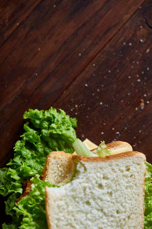 Tasty and fresh sandwiches on cuttig board over a dark wooden background, close-up. Yummy sandwich...