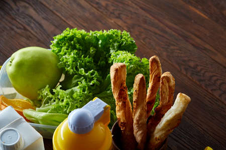 Continental breakfast with fresh pastry, fruits, greenery and beverages over light textured...
