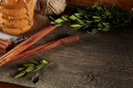 Christmas composition with pile of cookies stucked with ribbon, cinnamon sticks and dried oranges on...