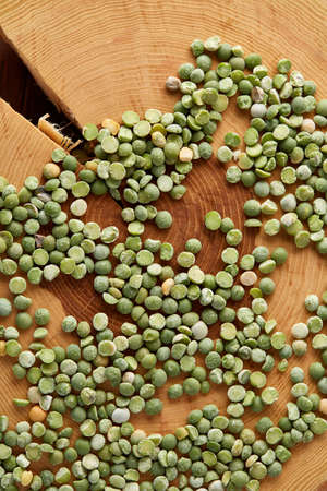 Green peas on a wooden log, close-up, top view, selective focus. Some copy space for your inscription. Studio shot. Macro. Nutritious organic protein. Healthy food concept. Healthy eating, dieting.の写真素材