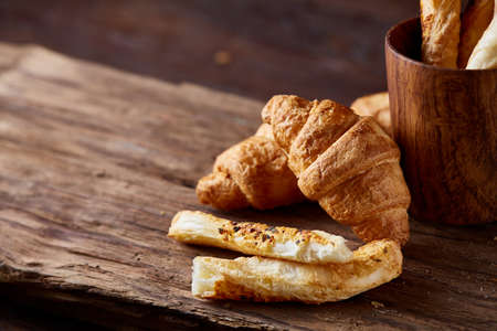 Tasty buttery croissants on an old wooden table, close-up, selective focus, shallow depth of field....