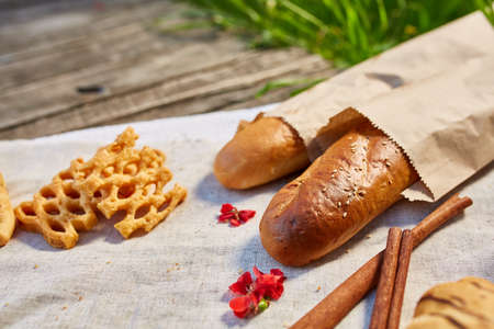 Picnic on a green lawn, pastries and vegetables on a homespun tablecloth, summer season, flat lay,...