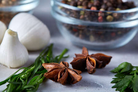 Mediterranean spice and herbs on white textured background, top view, close-up, selective focus. Italian cuisine. Healthy diet concept. Healthy cuisine. Garlic, rosemary, anise star and parsley on spicy background.の写真素材