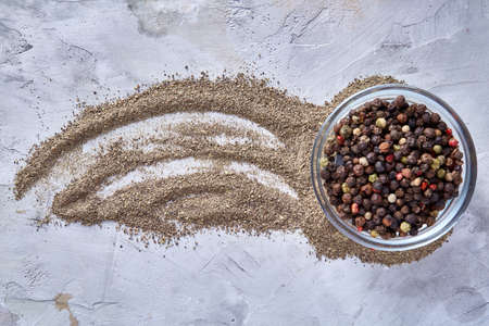Defocused black pepper corns in glass bowl with clipping path on white background, top view,...