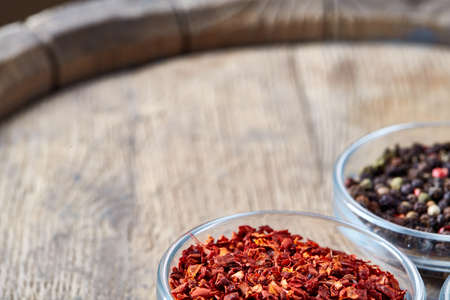 Bowls with different types of spicy on wooden barrel, top view, close-up, selective focus....
