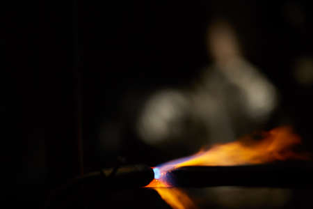 Treatment of molten metal in the blacksmith workshop on blurred background, close-up. Old-fashioned manufacturing. Manual metalindustry. Traditional crafts. Art and crafts concept.の写真素材