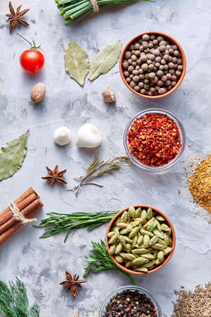 Transparent glass bowls with peppercorns and dried chilly among garlic, anise star and other spicies on white textured background, close-up, top view, selective focus. Aromatic flavour. Organic food background. Healthy lifestyle concept.の写真素材