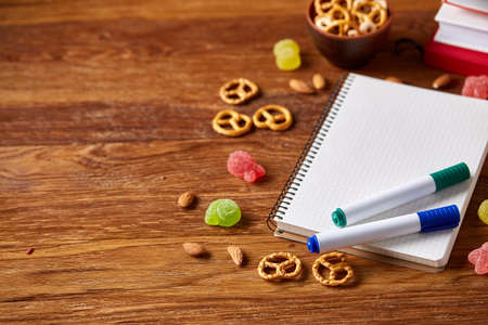 A notebook, two markers and banana in plastic lunchbox on a wooden table, copy space for text, selective focus. School lunch concept. Nutritious snack for students and kids. Healthy eating concept.の写真素材