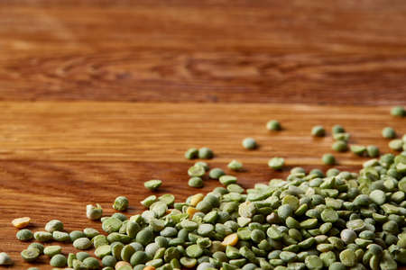 Green peas on rustic wooden background, close-up, top view, selective focus. Some copy space for your inscription. Studio shot. Macro. Nutritious organic protein. Healthy food concept. Healthy eating, dieting.の写真素材