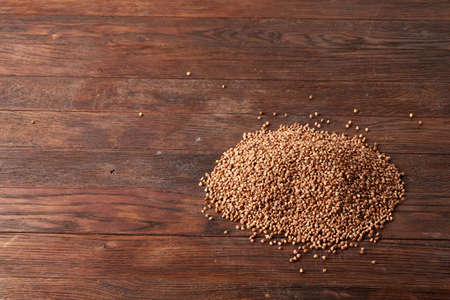 Buckwheat groats on wooden background, top view, close-up, selective focus. Some copy space for your text. Premium cereal for healthy eating or dieting. Healthy food concept.の写真素材
