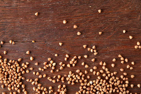 Buckwheat groats on wooden background, top view, close-up, selective focus. Some copy space for your text. Premium cereal for healthy eating or dieting. Healthy food concept.の写真素材