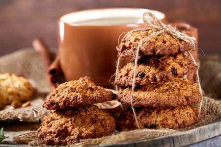Conceptual festive composition with a cup of hot tea, a large set of cookies, cinnamon sticks bunch...