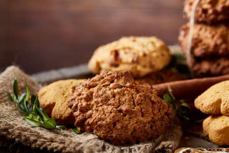 Conceptual composition with assortment of cookies, cinnamon sticks bunch and dried oranges on a...