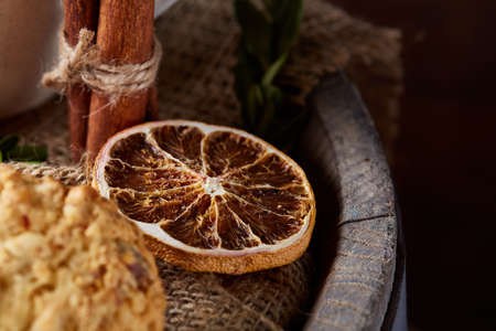 Conceptual composition with assortment of cookies, cinnamon sticks bunch and dried oranges on a...