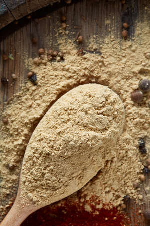 Top view of a wooden spoons full of paprica and black pepper on wooden barrel background, selective...
