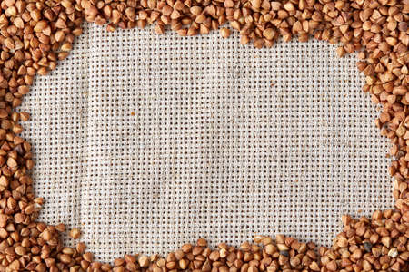 Buckwheat groats on burlap background, top view, close-up, selective focus, shallow depth of field, vertical.の写真素材